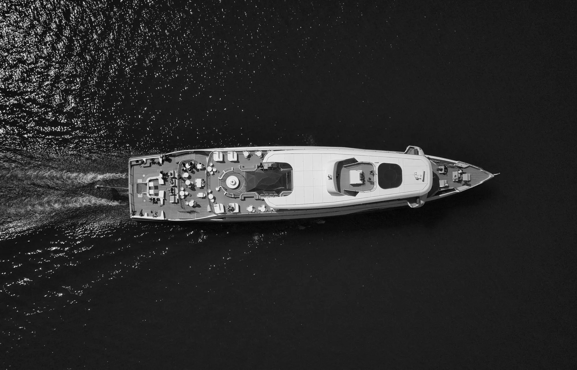 A superyacht under way seen from above, its wake behind it