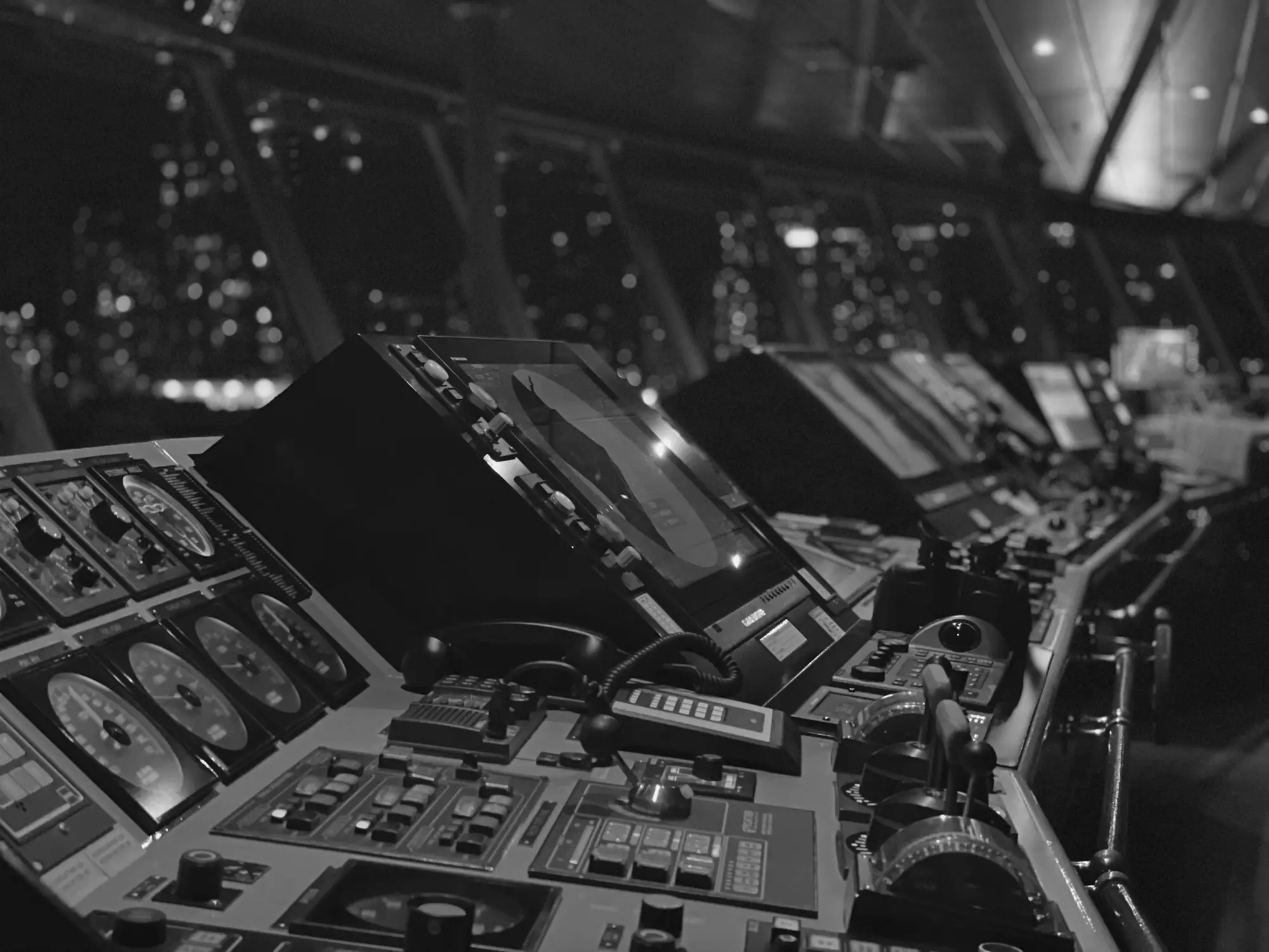 The bridge of a megayacht at night, screens and controls lit