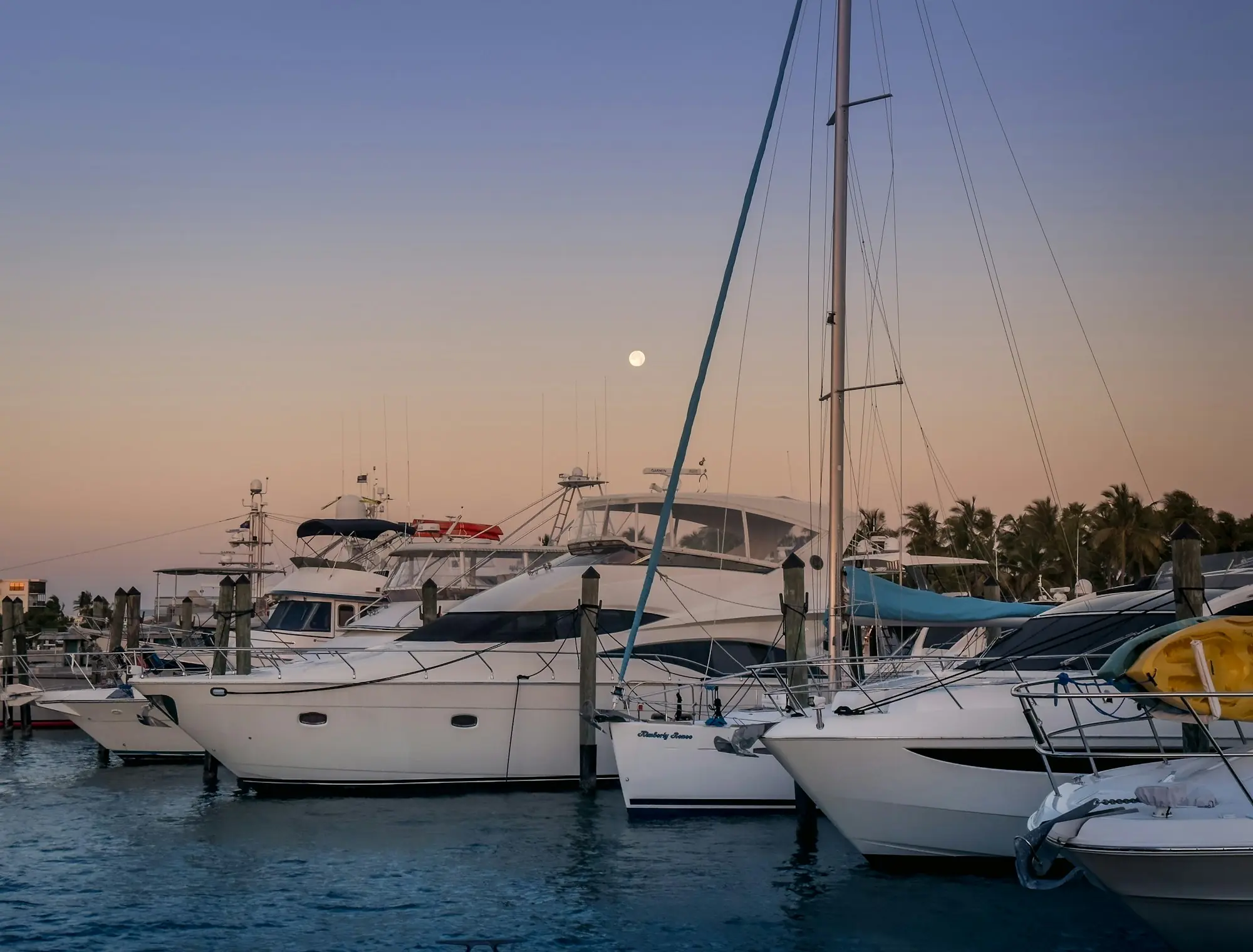 Yachts moored in a harbour under a twilight sky